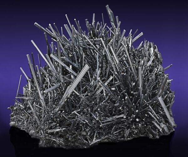 A massive cluster of metallic stibnite crystals from the Wuning Mine in China.  Photo Credit: Robert M. Lavinsky